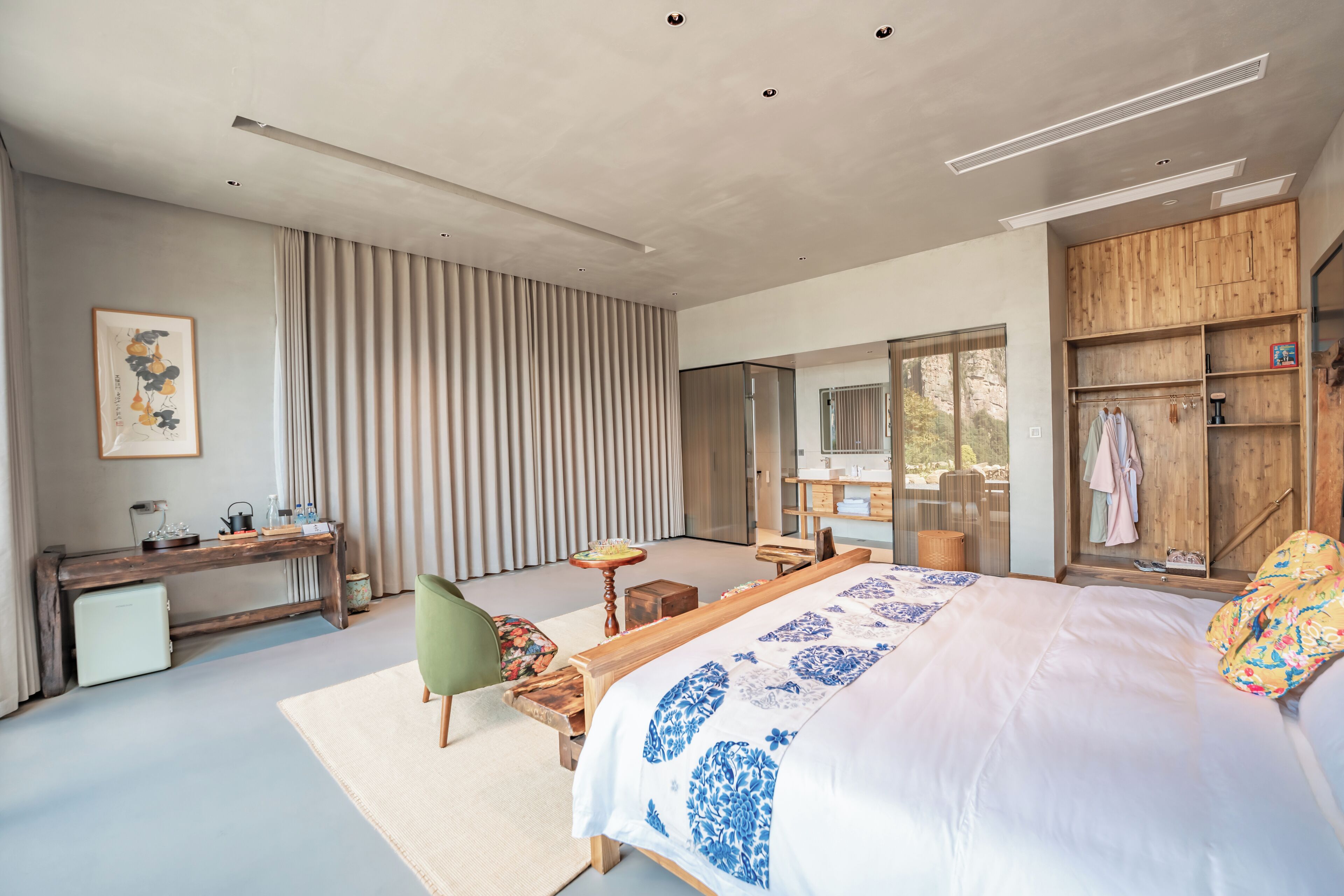 Un dormitorio moderno con una cama grande, un escritorio, una silla y un armario.