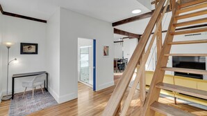 Un intérieur moderne avec un escalier en bois, un bureau avec une chaise et un téléviseur.