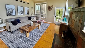 Un salon avec un canapé, une table basse et un tapis à motifs.