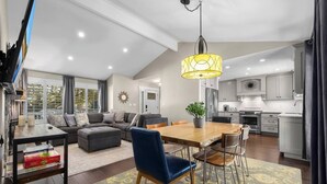 Un salon moderne avec un canapé, un pouf et une table à manger.