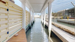 A covered walkway with wooden railings and a water channel.