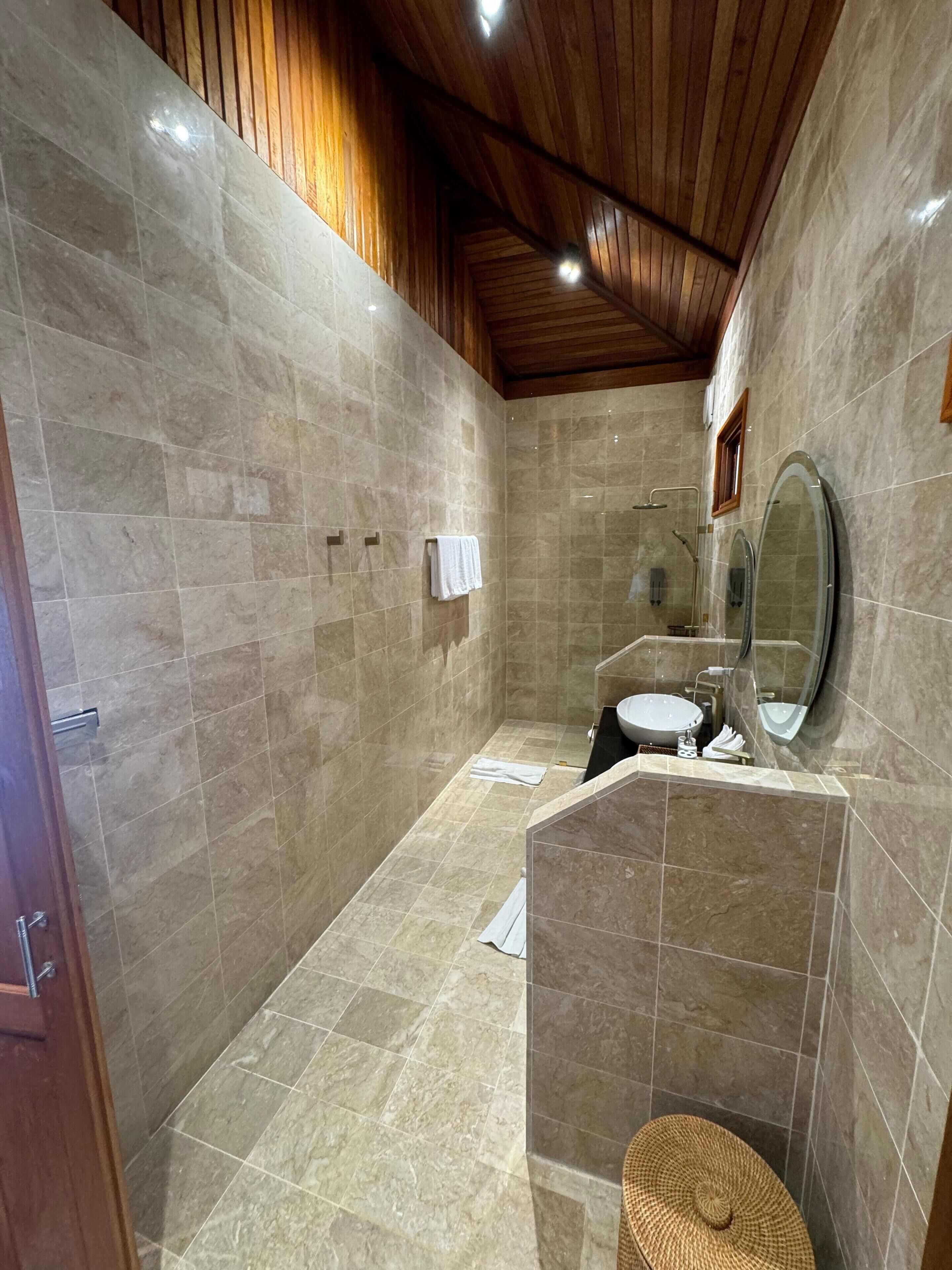A modern bathroom with a walk-in shower, a toilet, a sink, and a mirror.