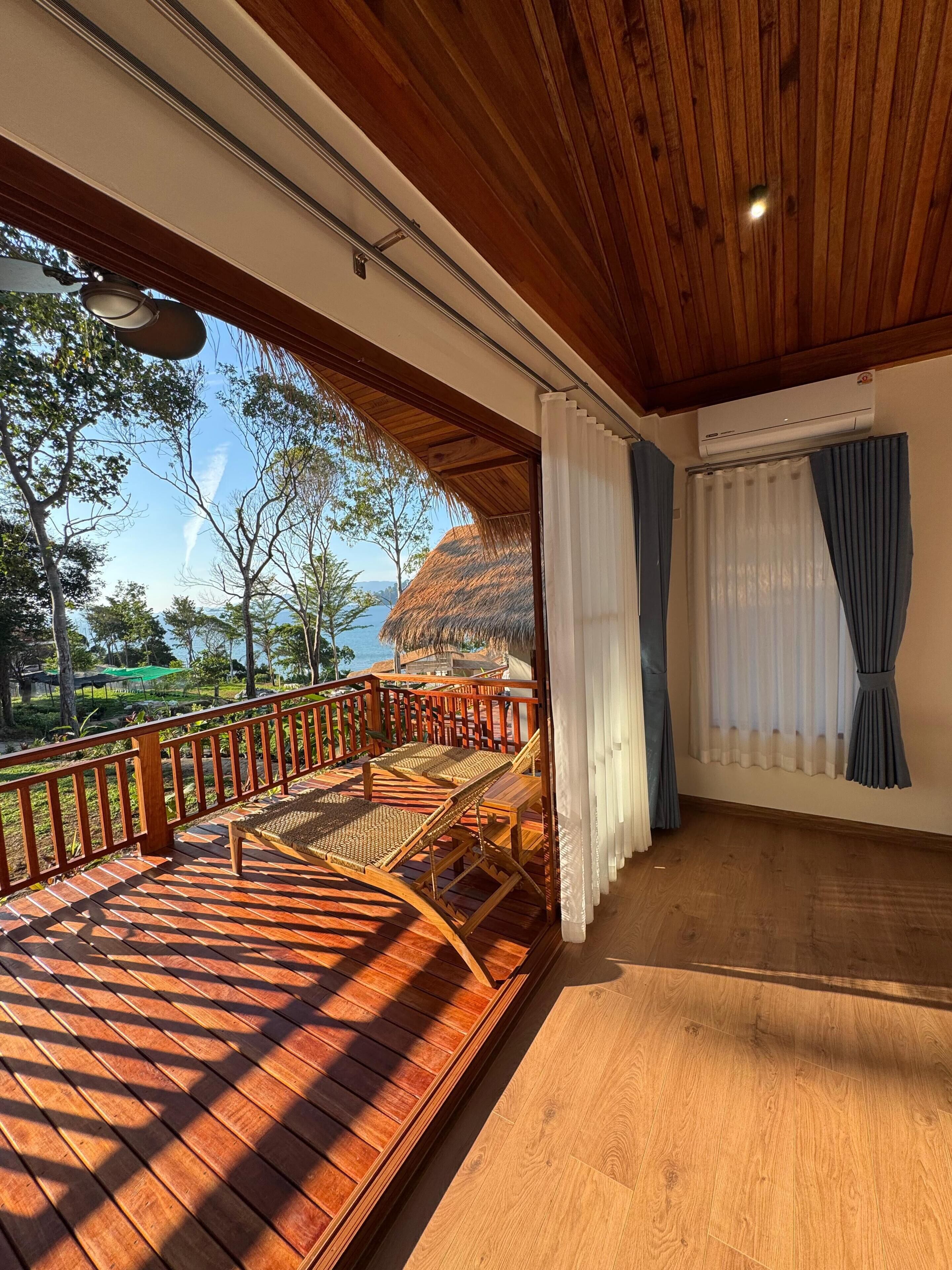 A wooden deck with a railing, a table, and two chairs.