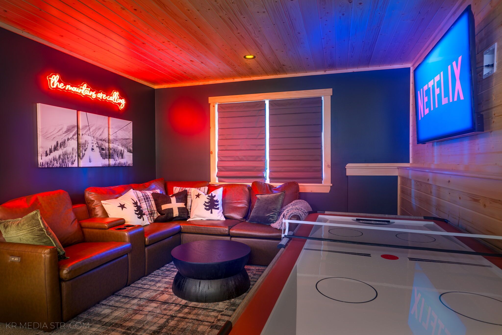 Una habitación acogedora con un sofá, una mesa y un televisor que muestra el logotipo de Netflix.