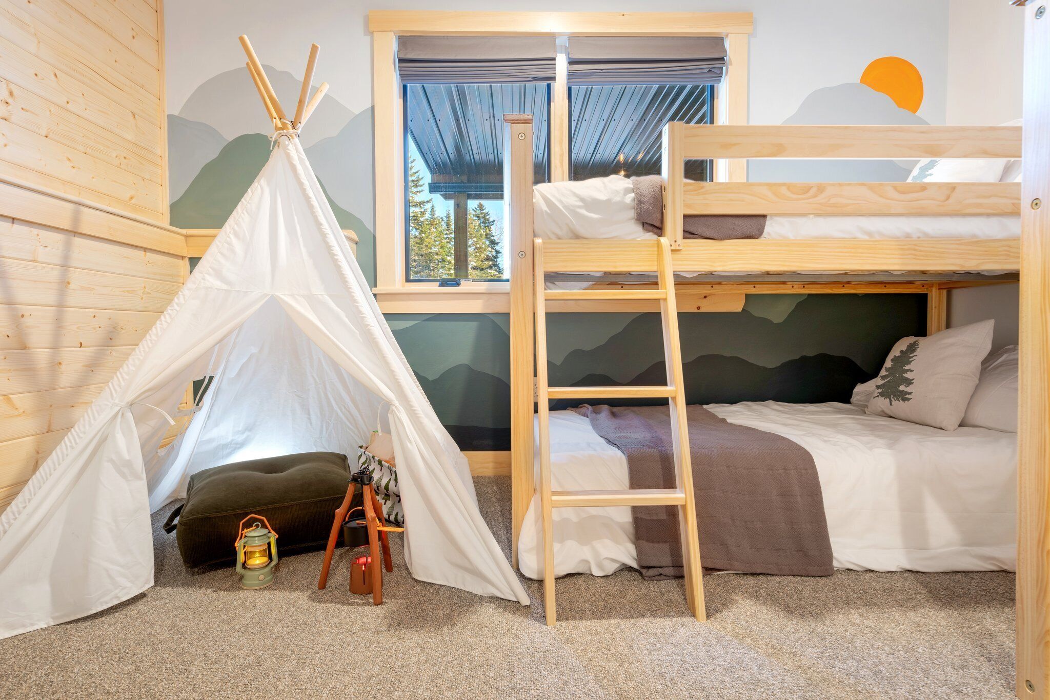 A cozy room with a bunk bed, a tent, and a ladder.