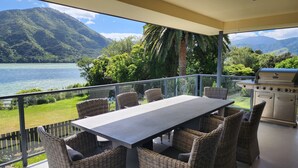 A balcony with a table and chairs, overlooking a lake and mountains. - Waterfront & spacious. Room for cars & boat trailer. 6KM from Havelock Marina (Havelock)