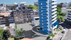 A modern high-rise building with a blue and white facade, surrounded by other residential buildings and a clear view of the sea. - Lovely apartment for 8 guests with A/C, WIFI, TV, balcony and pets allowed (Lignano Sabbiadoro)