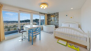 Un dormitorio moderno con un ventanal grande, un escritorio, una cama y una bañera.