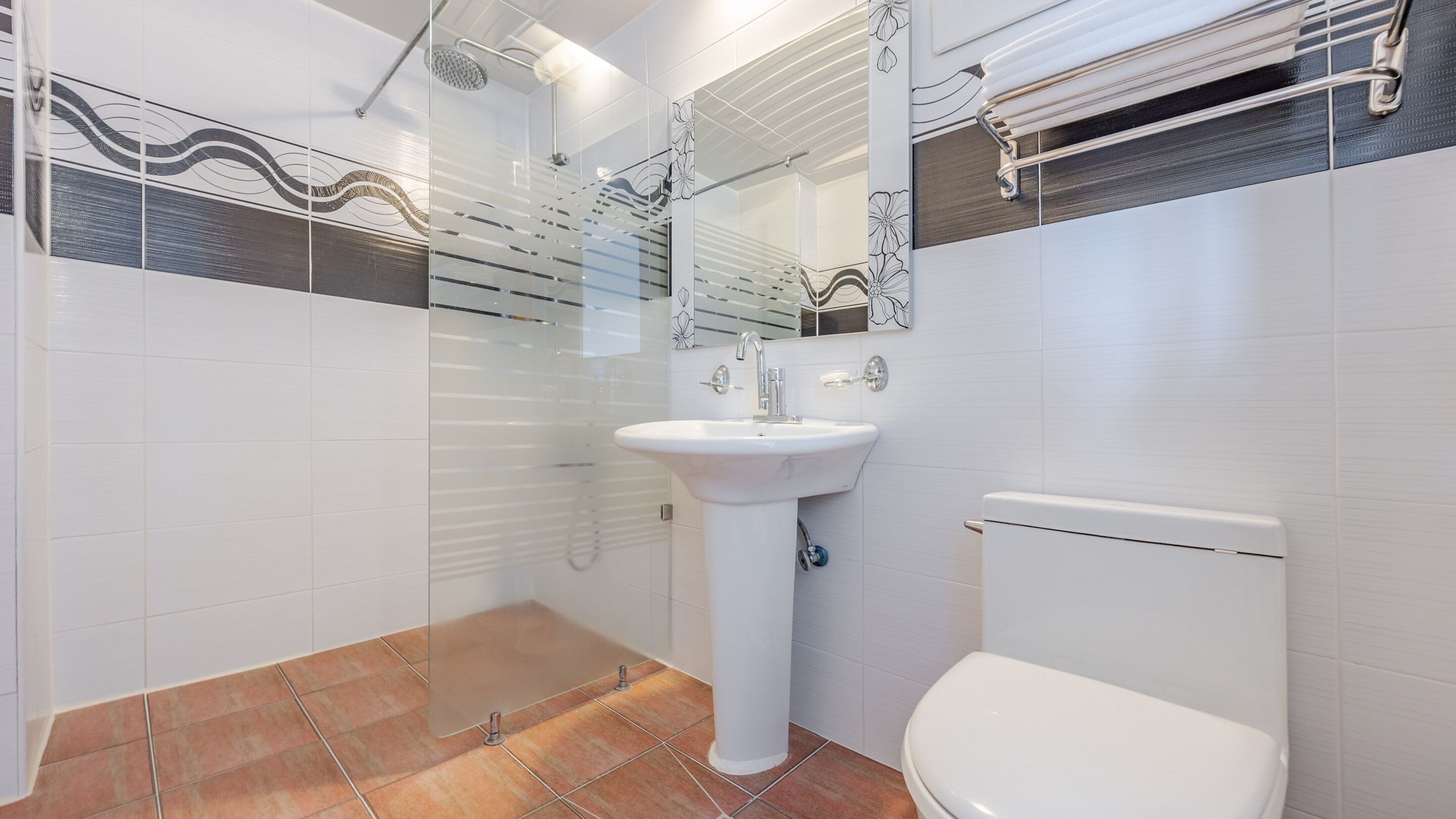 A bathroom with a white sink, a toilet, and a shower area.