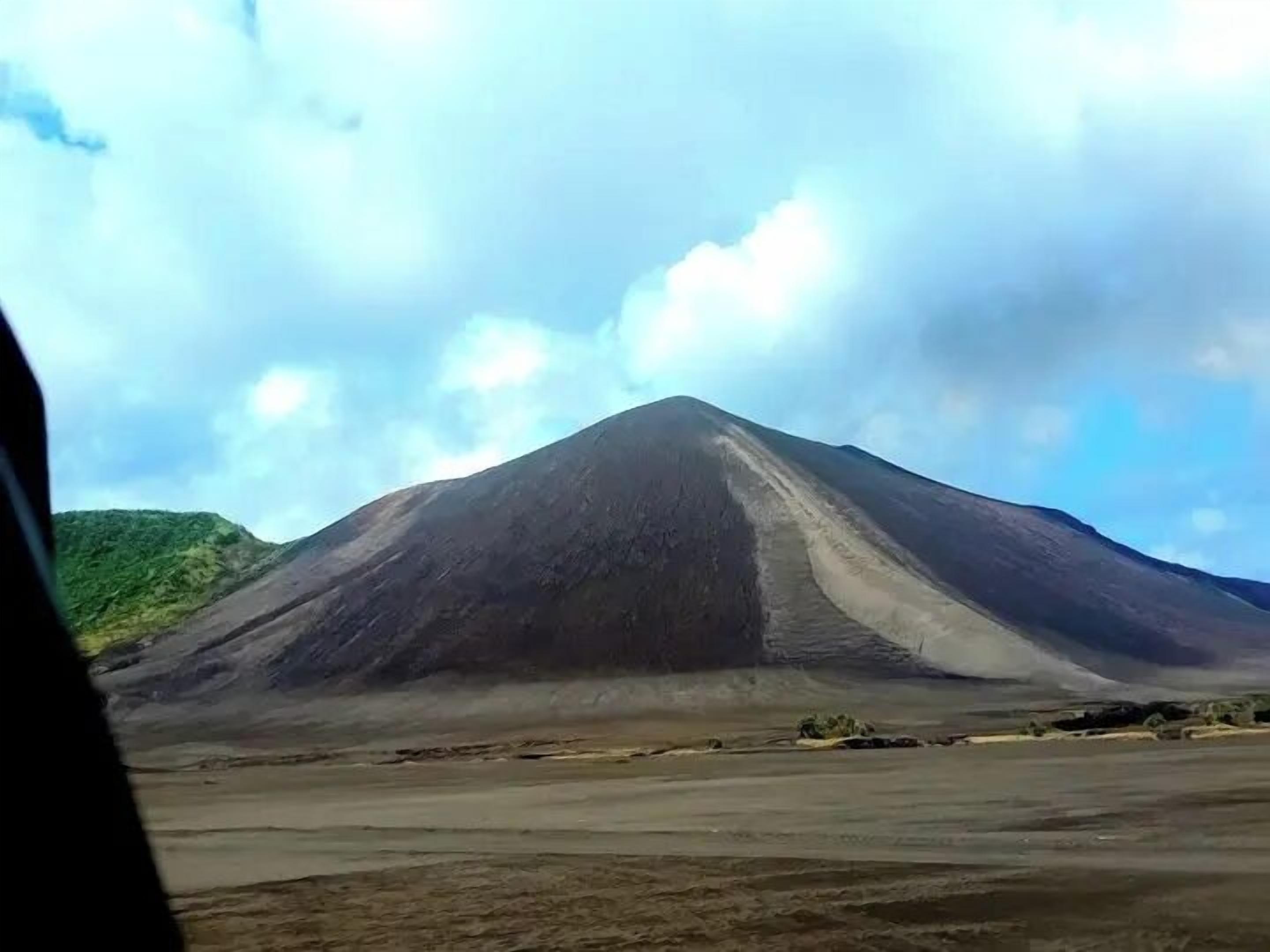 Une vaste montagne aride, sous un ciel dégagé.