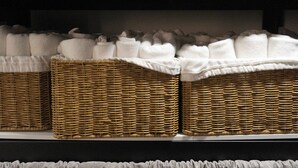 Wicker baskets filled with white towels on a shelf. - INN THE HOUR_Myeongdong (Seoul)