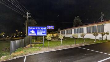 Un letrero de motel que enumera sus servicios, entre ellos, acceso las 24 horas, Wi-Fi gratuito, aire acondicionado, piscina, televisor inteligente y una sala de conferencias.