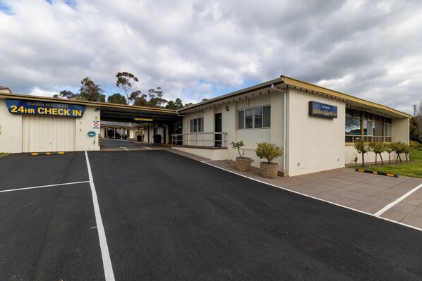 A motel with a 24-hour check-in service, a covered parking area, and a welcoming sign. - Golden Hills Motel (Golden Square)