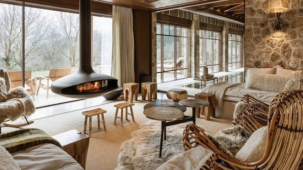 A cozy interior with a fireplace, stone walls, and comfortable seating.