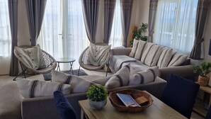 A living room with a sofa, two wicker chairs, a small table, and a potted plant. - SeaView,Sleeps 4to6,Pet friendly, Parking (Wareham)