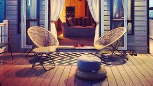 A cozy cabin with two wicker chairs, a small dining table, and a checkered floor. - SeaView,Sleeps 4to6,Pet friendly, Parking (Wareham)