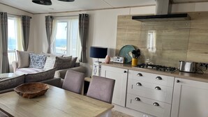 A modern kitchen with a wooden countertop, a dining table, and a built-in oven. - SeaView,Sleeps 4to6,Pet friendly, Parking (Wareham)