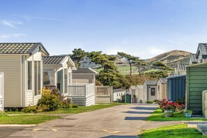Een rij mobiele woningen met een verharde oprit en een gazon ervoor.