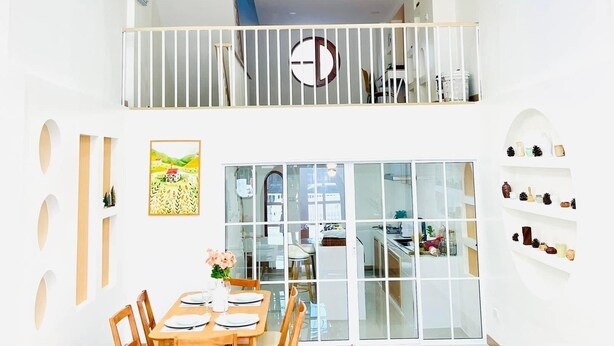 Ein modernes Interieur mit Essbereich, Treppe und Balkon.