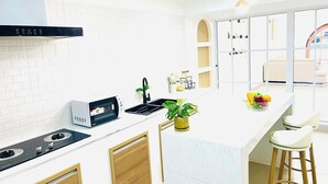 Eine moderne Küche mit Einbauherd, Spüle und einer Arbeitsplatte mit Pflanze und Obstschale.