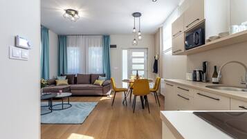 A modern apartment with a living room, dining area, and kitchen.
