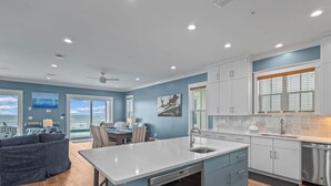 Una cucina moderna con isola centrale, elettrodomestici in acciaio inossidabile e zona pranzo con vista.