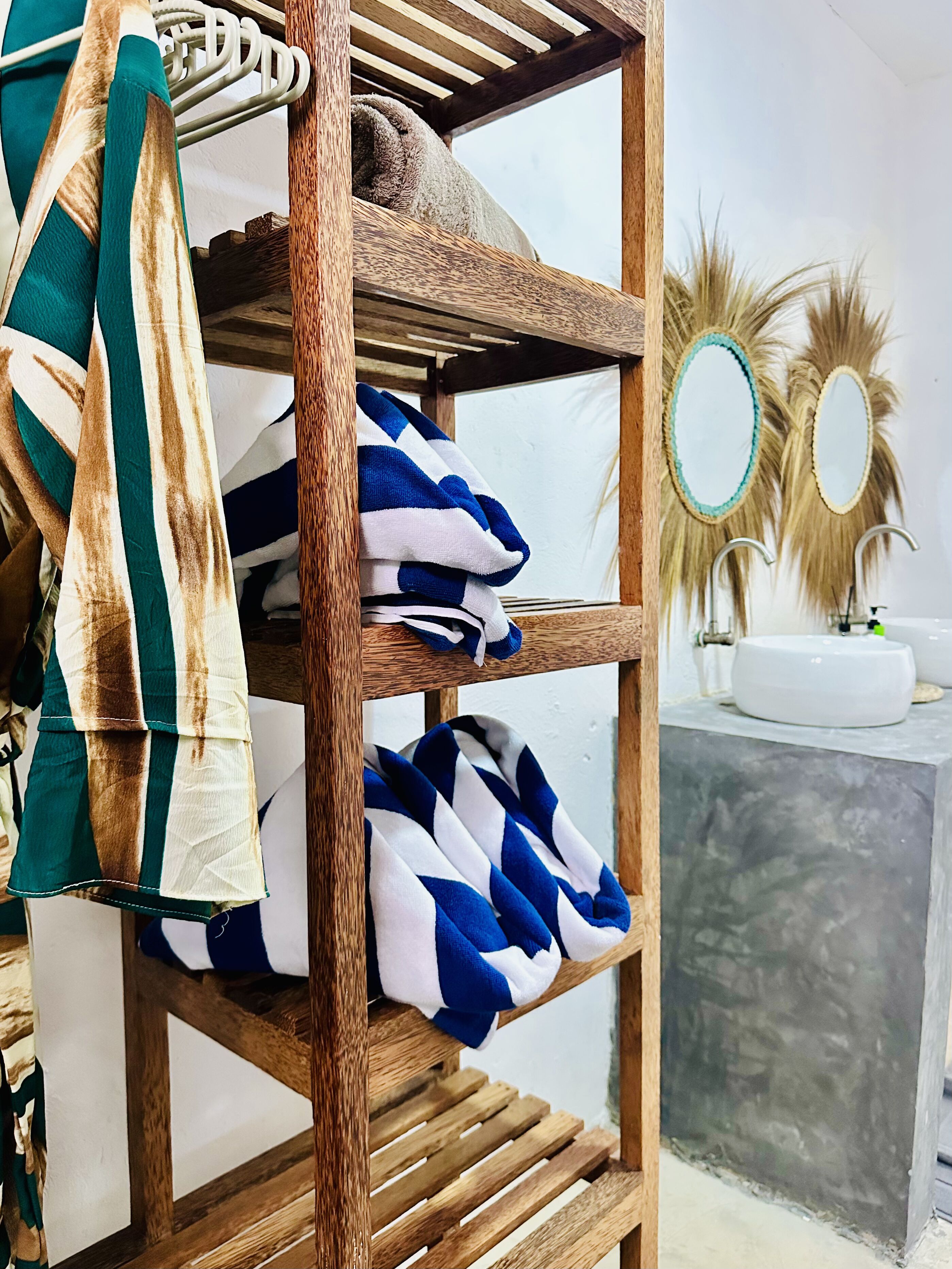 A wooden shelf with towels and a mirror.