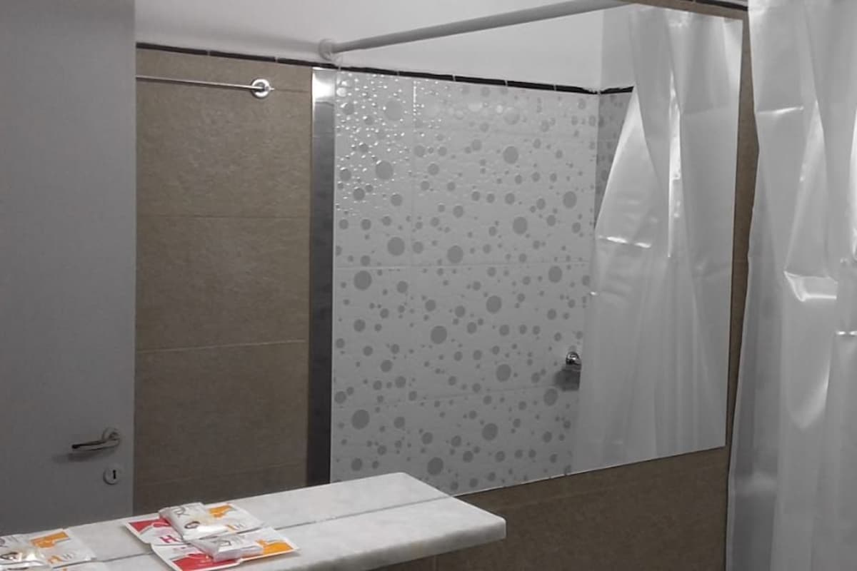 Un baño con ducha, inodoro y lavabo.