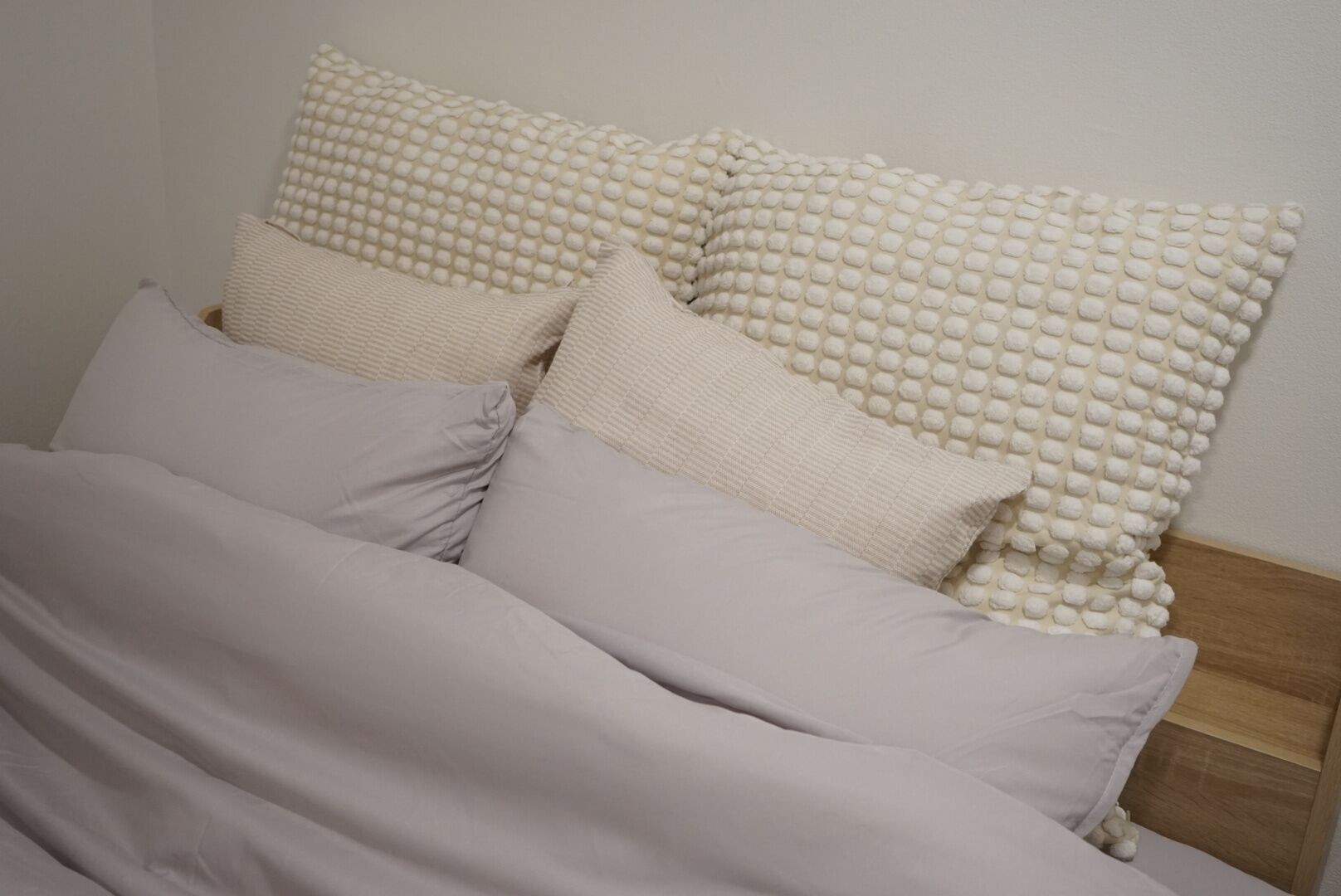 A bed with multiple pillows and a blanket.
