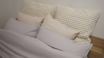 A bed with multiple pillows and a blanket.