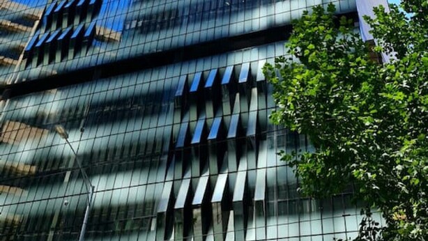 A tall, modern skyscraper with a reflective glass facade and a prominent vertical design element. - Melbourne CBD | High Rise Traveller's Paradise (Melbourne)
