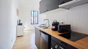 Una cocina moderna con encimera negra, tostadora y lavavajillas.