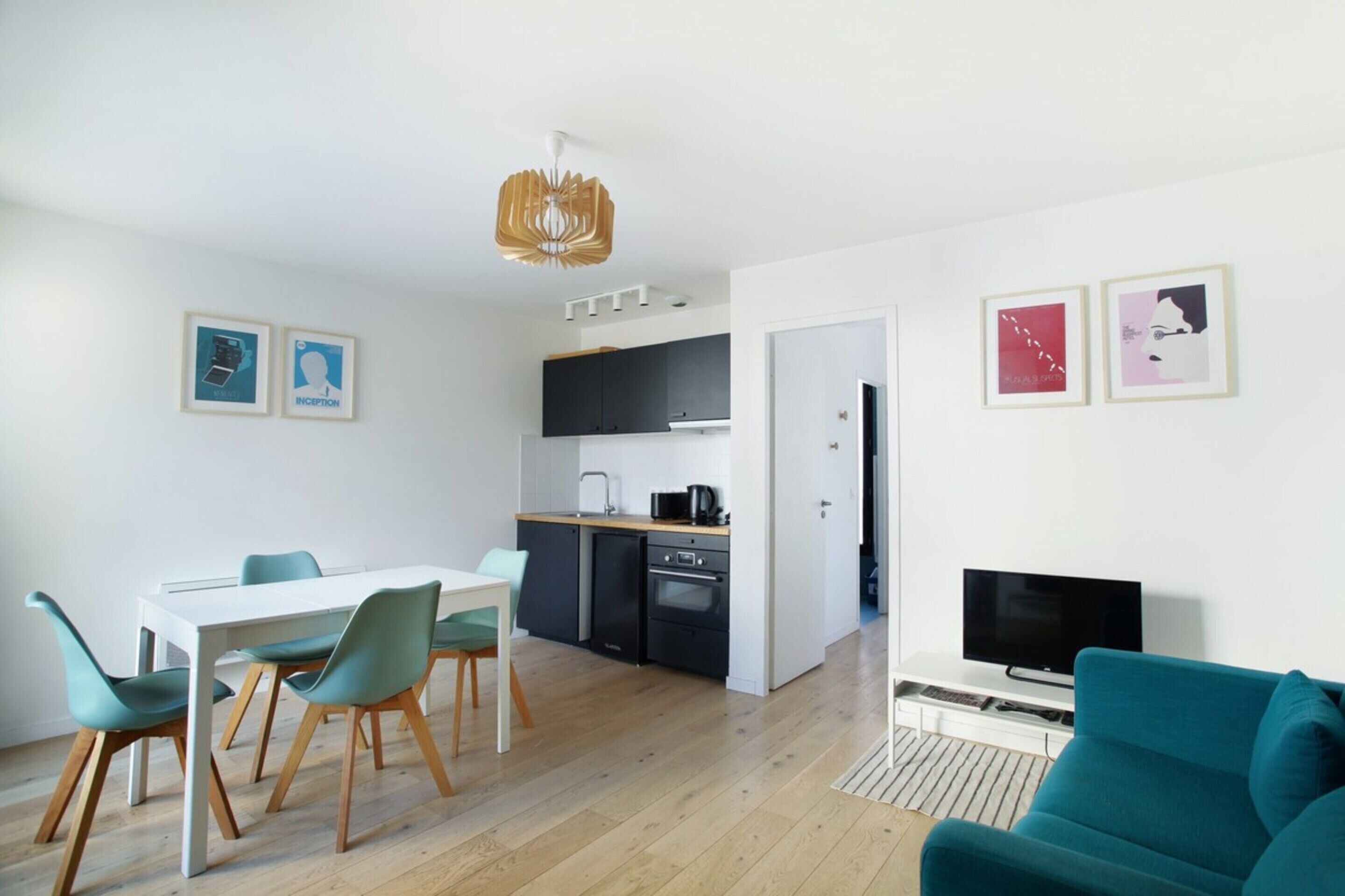 A modern apartment with a dining area, kitchen, and living room.