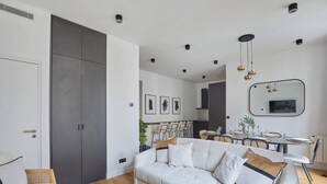 Una sala de estar moderna con sofá, comedor y un armario grande.