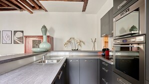A modern kitchen with grey cabinetry, a stainless steel sink, and a built-in oven. - Superb Parisian Apartment Center of Paris (Paris)
