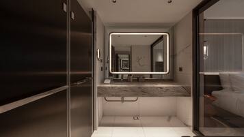 A modern bathroom with a large mirror, a marble countertop, and a separate shower area.