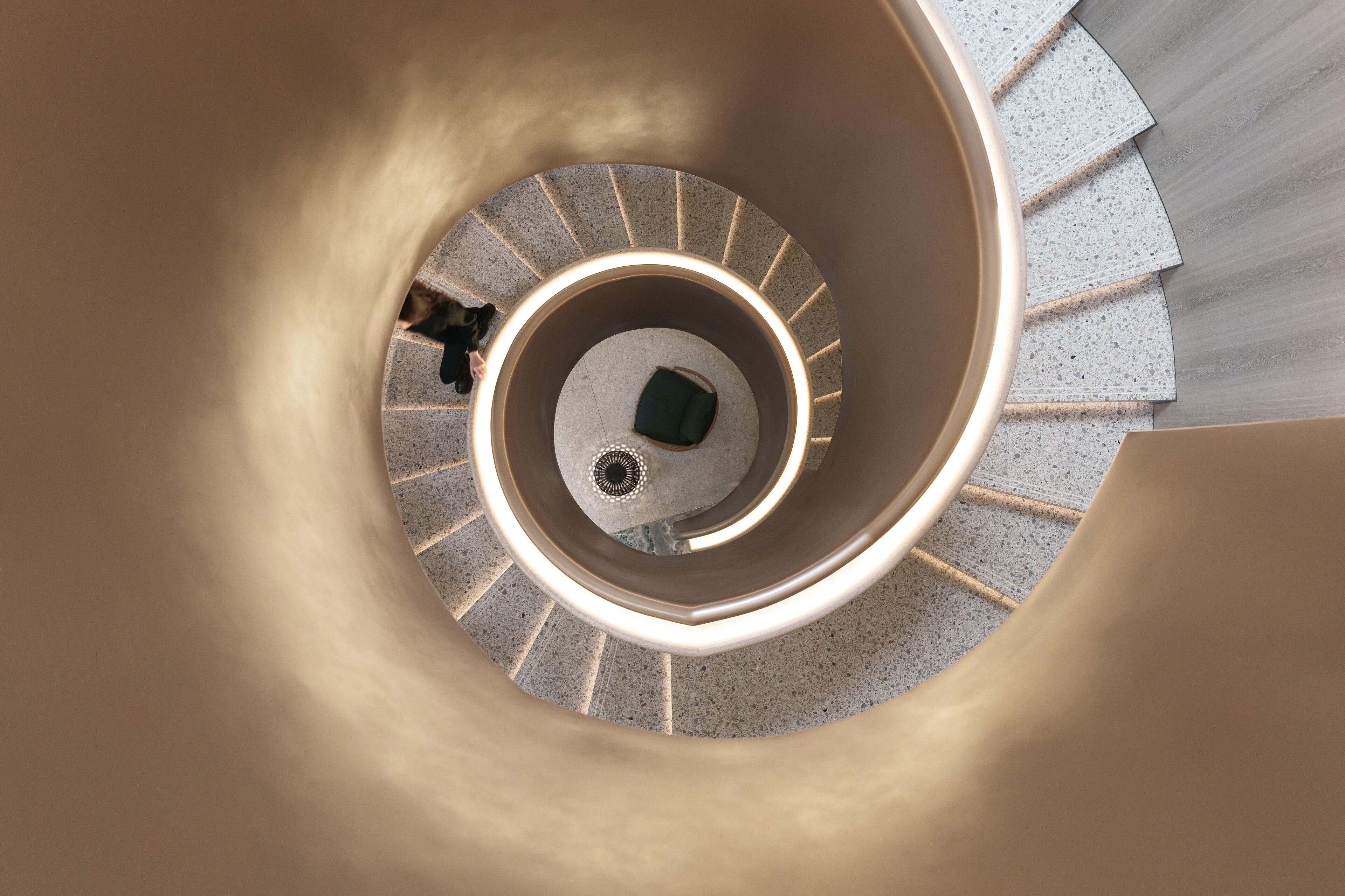 A spiral staircase with a central column and a handrail.