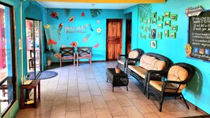 Una habitación con pared azul, muebles de madera y un mural tropical.