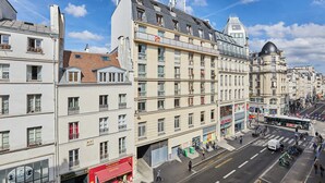 Ein mehrstöckiges Gebäude mit Balkonen, eine Fußgängerstraße und ein Bus.
