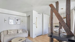 Ein modernes Wohnzimmer mit einer Couch, einem Couchtisch und einem Essbereich mit Tisch und Stühlen.