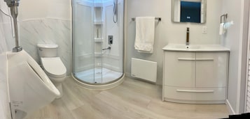 Bañera, secador de pelo, pantuflas, piso con calefacción en el baño