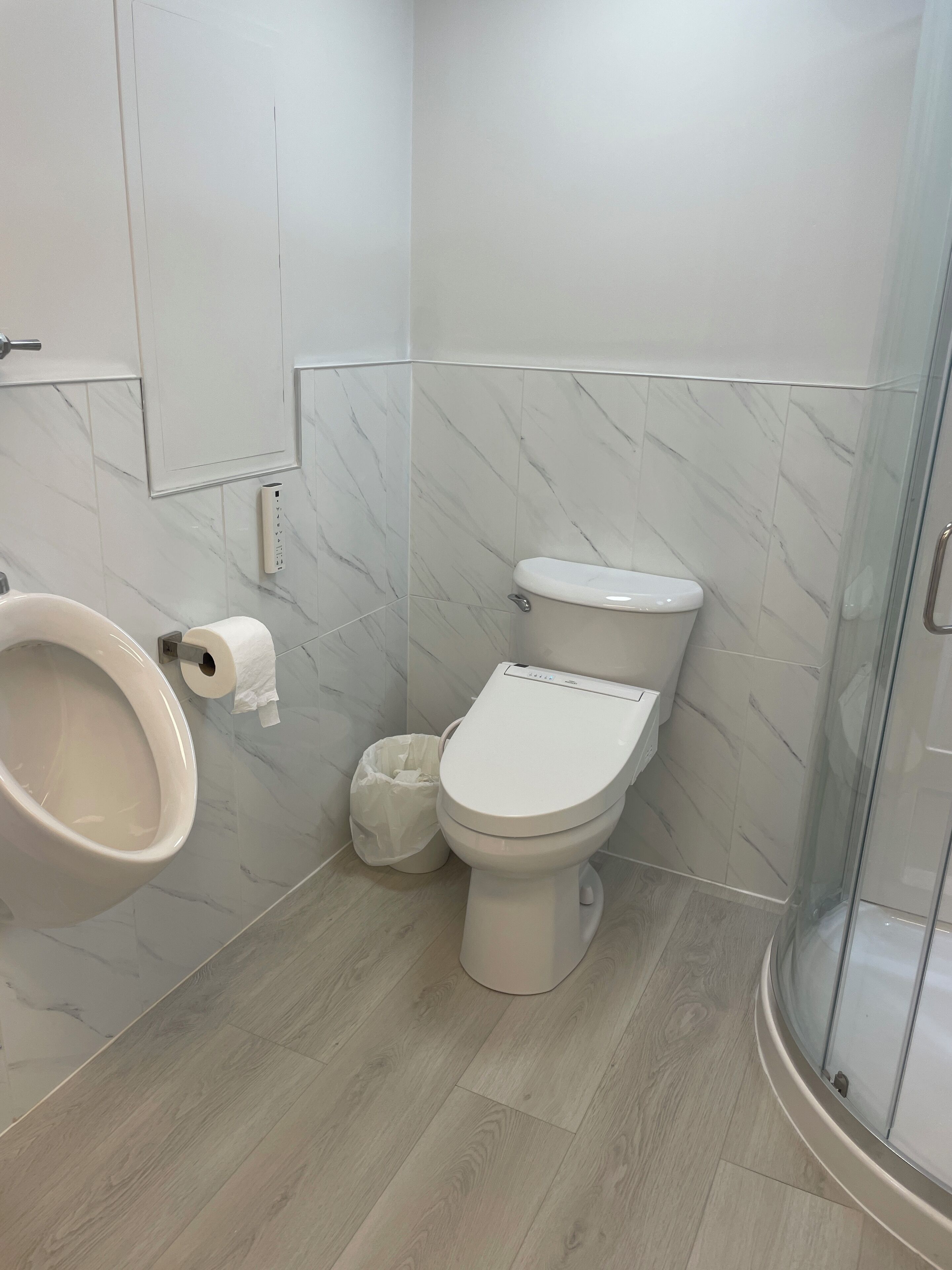 A modern bathroom with a toilet, bidet, and shower.