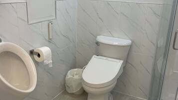 A modern bathroom with a toilet, bidet, and shower.