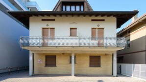 A two-story building with a balcony, a sign reading "Villa Guglielmo Anna," and a brick entrance. - Cosy apartment for 5 guests with WIFI, A/C, TV, terrace and pets allowed (Lignano Sabbiadoro)