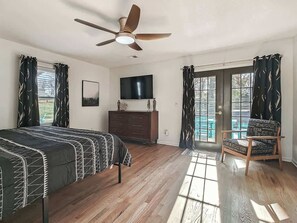 Ein Schlafzimmer mit Bett, Kommode, Fernseher und Stuhl.