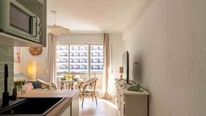 A modern kitchen with a microwave, sink, and dining area with chairs and a table.