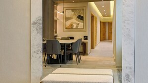 Een modern interieur met een eethoek, een bank en een gang naar een andere kamer.
