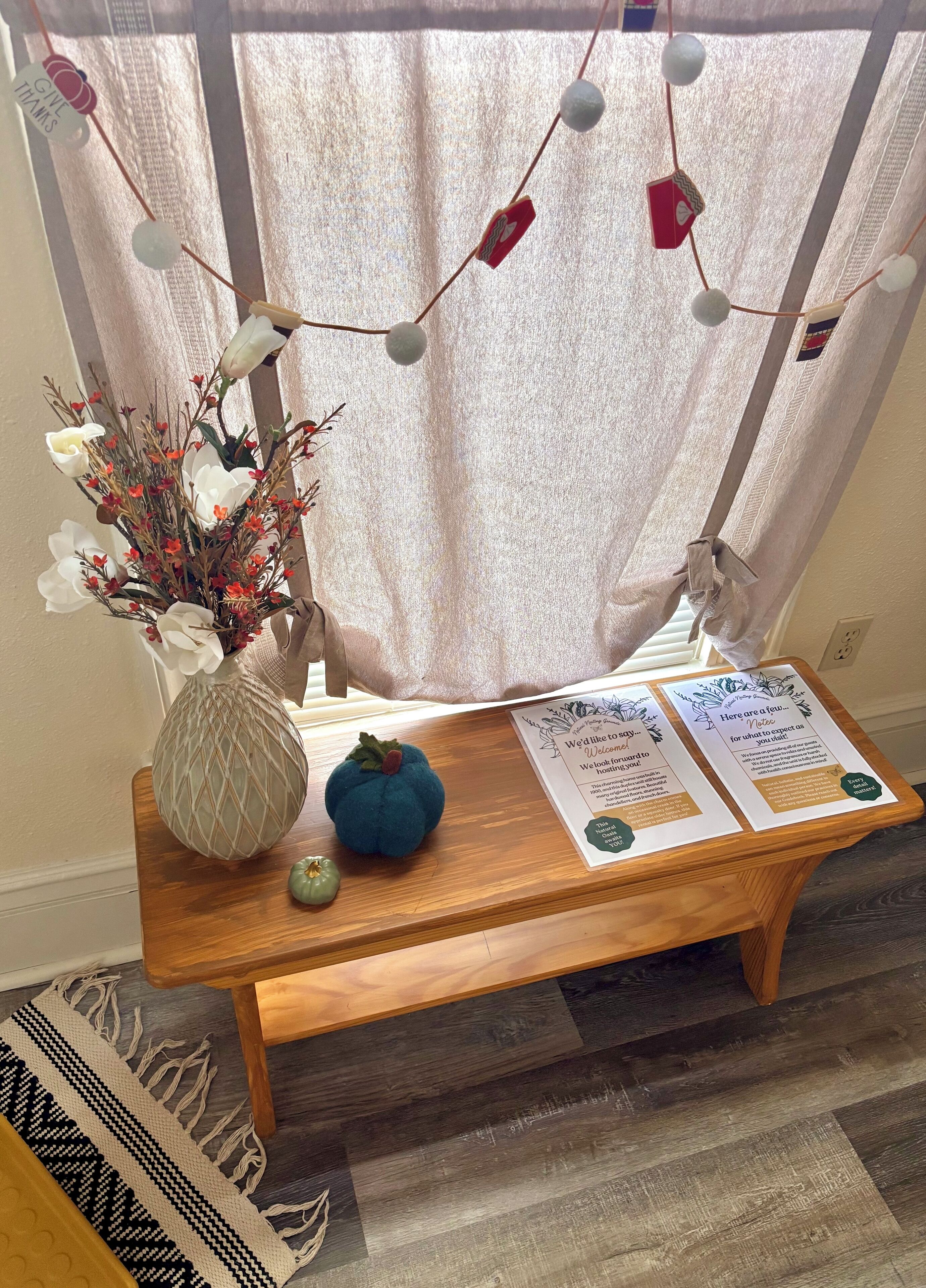 Un banc en bois agrémenté d’un vase de fleurs, d’une petite décoration en forme de citrouille et de fiches d’information.