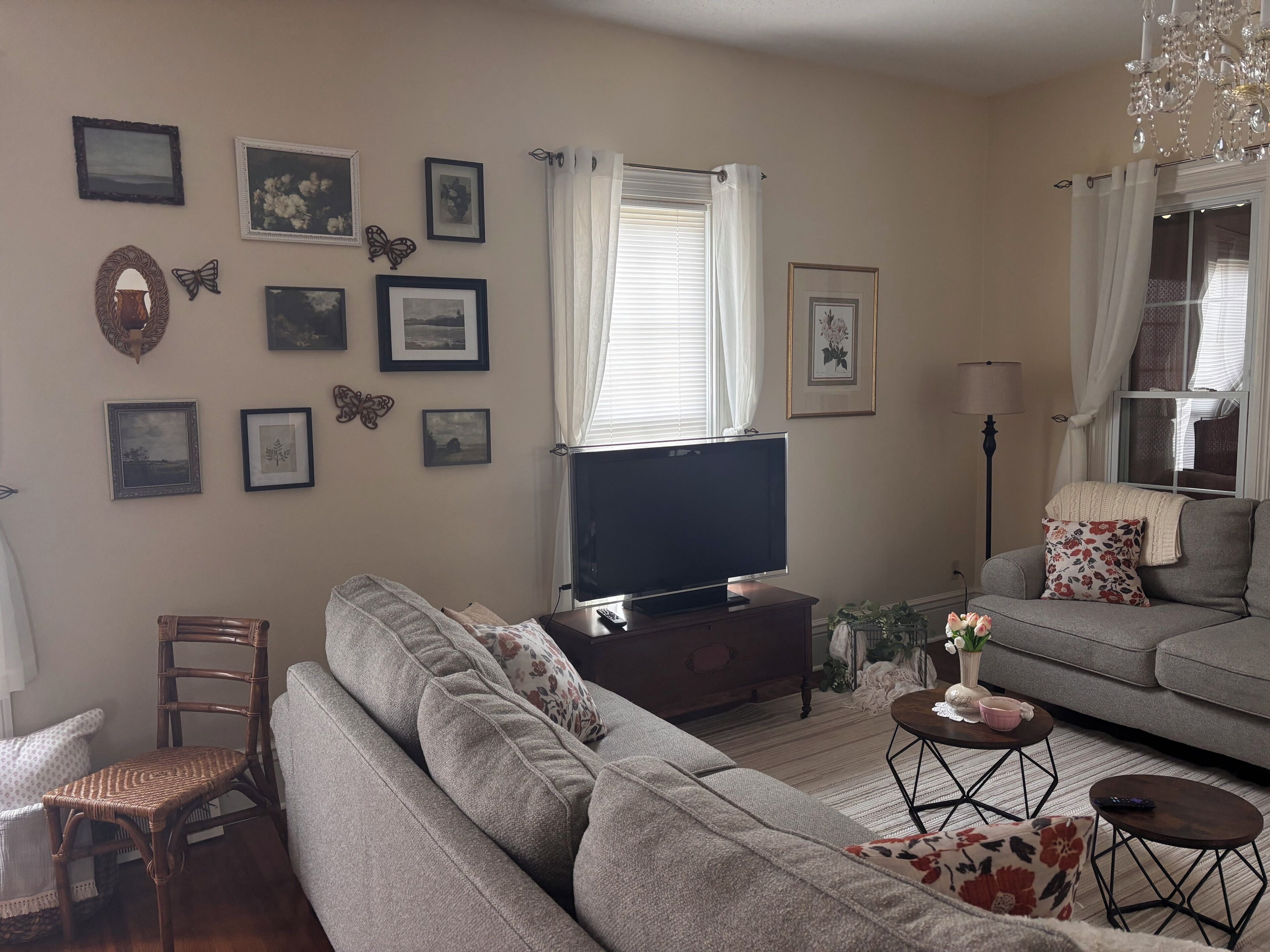 Un salon avec un canapé, un téléviseur, une table basse et un fauteuil.