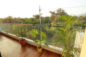 Un balcon avec un plancher en bois et des plantes en pot.
